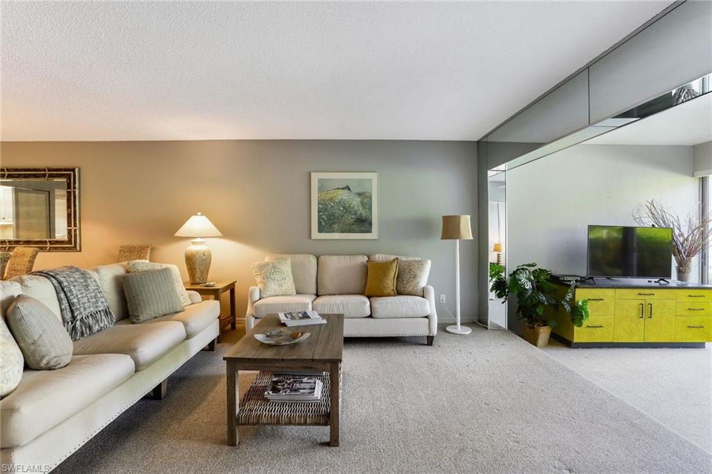 4155 Crayton Road, Unit 108 Naples, FL 34103 - Photo 6 of 32 a living room with furniture and a flat screen tv