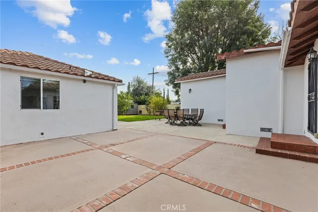 a backyard of a house with table and chairs