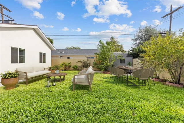 a view of a house with backyard sitting area and garden