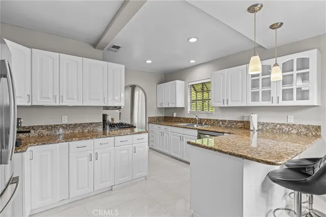 a kitchen with stainless steel appliances granite countertop a sink and cabinets