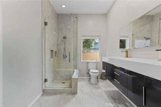 a bathroom with a double vanity sink toilet and shower