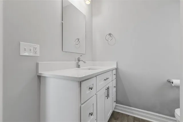 a bathroom with a sink and mirror with toilet