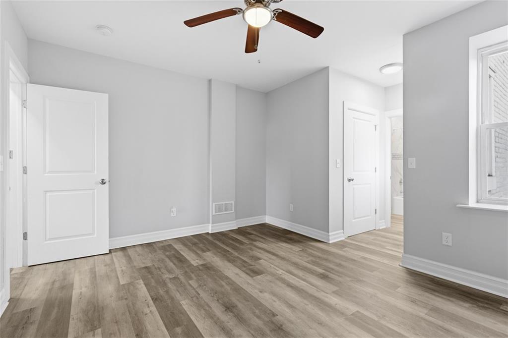 714 Cherokee Street Pittsburgh, PA 15219 - Photo 21 of 26 an empty room with wooden floor chandelier fan and windows