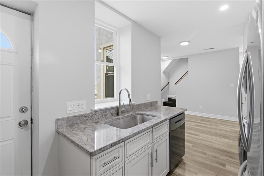 714 Cherokee Street Pittsburgh, PA 15219 - Photo 6 of 26 a kitchen with a sink granite counter tops and a wooden floor