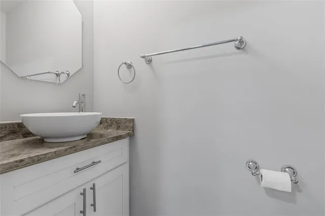 a bathroom with a granite countertop sink and a mirror