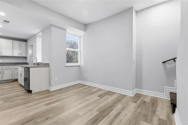 a view of empty room with wooden floor and window