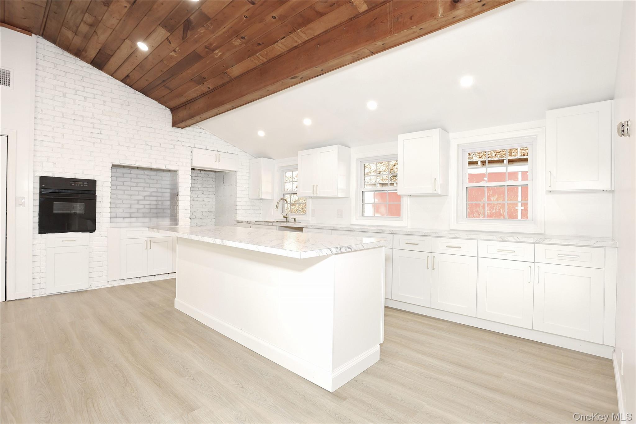 84 Pine Hill Road Chester, NY 10918 - Photo 11 of 18 Kitchen featuring white cabinets, a center island, oven, light wood-style flooring, and light stone countertops