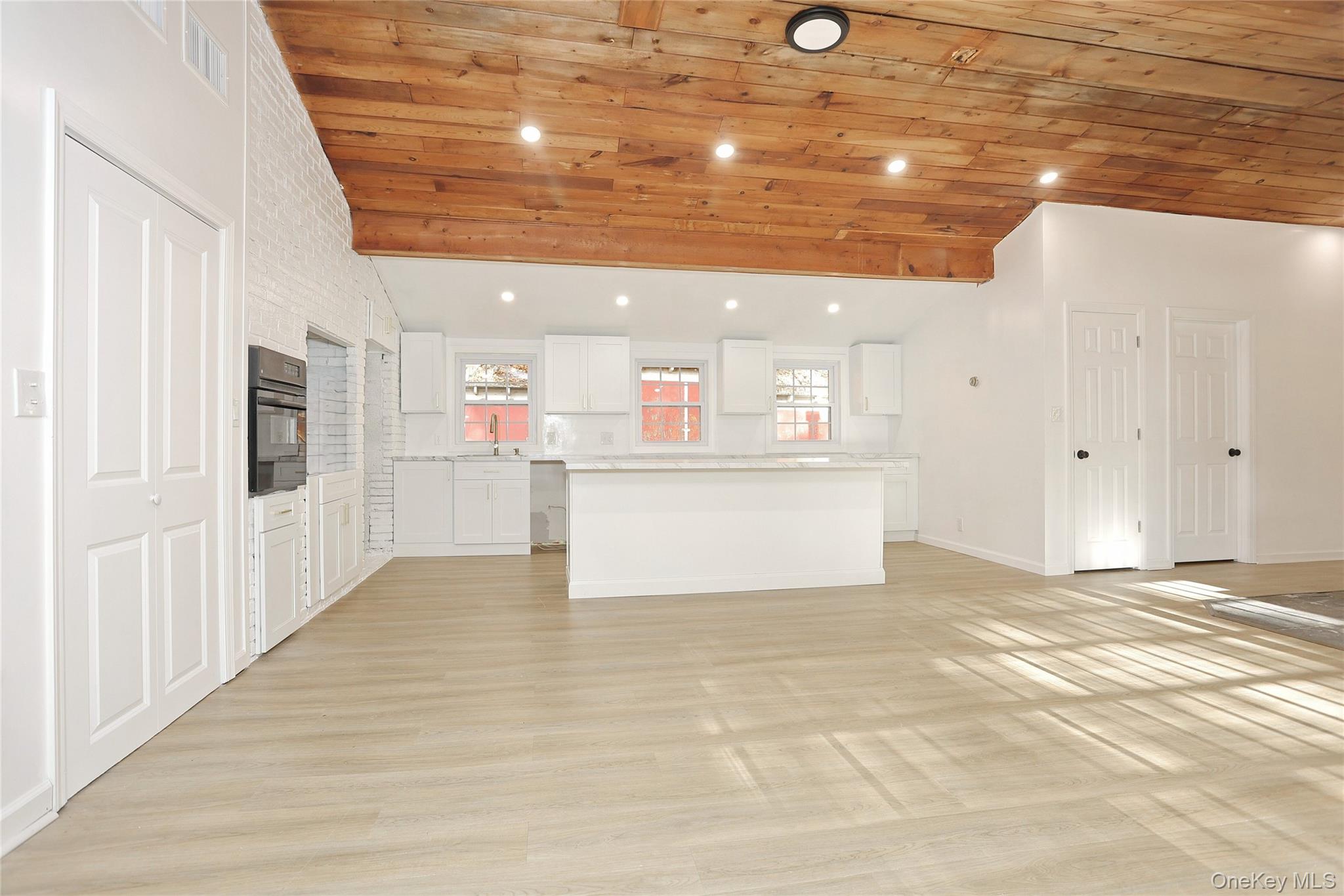 84 Pine Hill Road Chester, NY 10918 - Photo 10 of 18 Kitchen with white cabinets, light countertops, wood ceiling, light wood-type flooring, and a center island