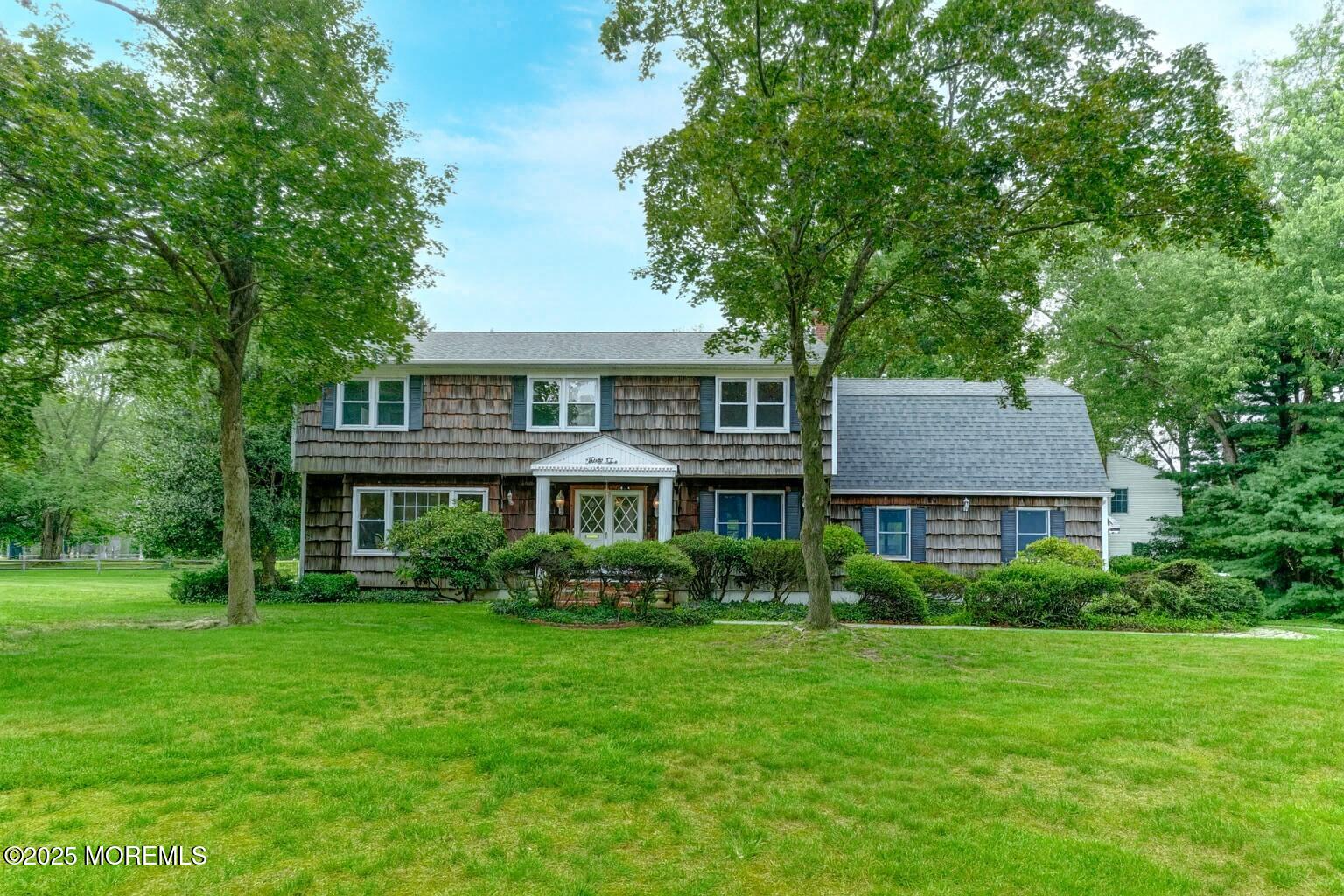 a front view of a house with a yard and trees
