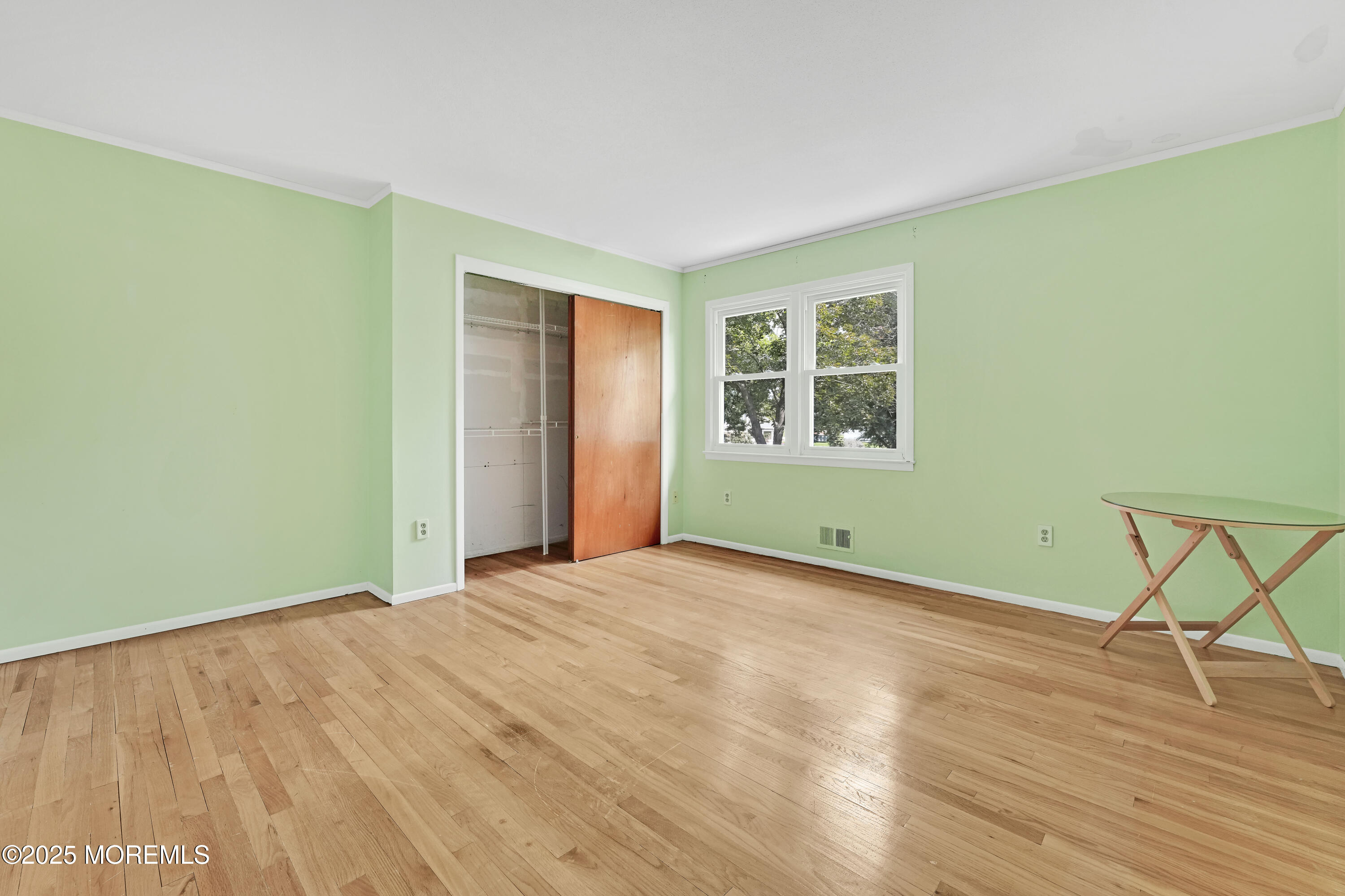 32 Woods Road Freehold, NJ 07728 - Photo 23 of 35 a view of an empty room with wooden floor and a window