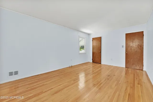 a view of an empty room and wooden floor