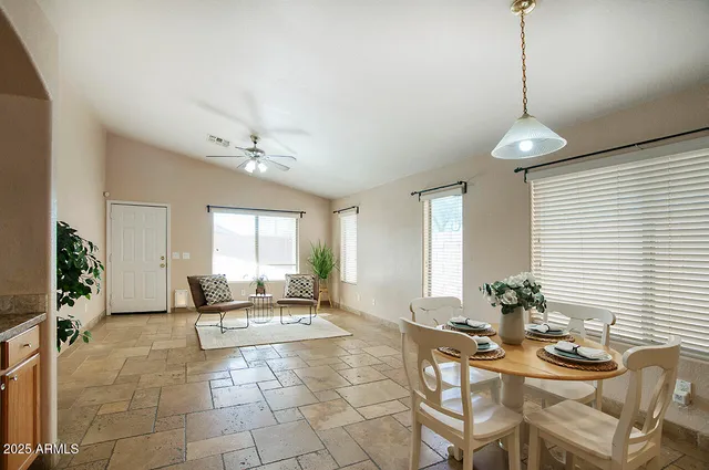 a living room with patio furniture and a chandelier