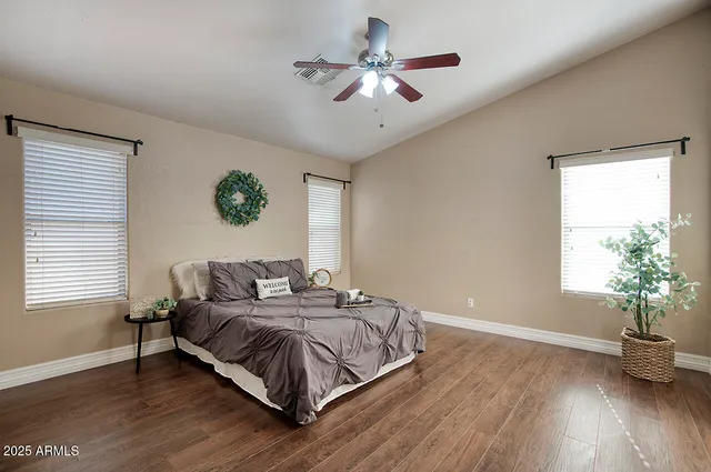 a bedroom with a bed ceiling fan and a window