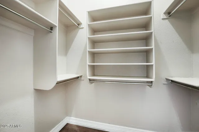 a view of walk in closet with empty racks