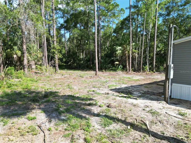 a backyard of a house with large trees