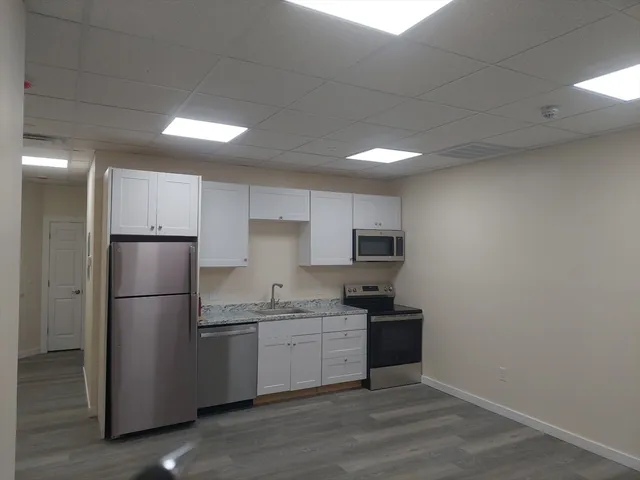 a kitchen with a refrigerator sink and cabinets