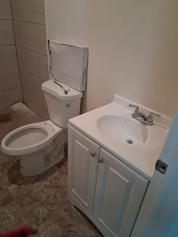 a white toilet sitting next to a bathroom sink