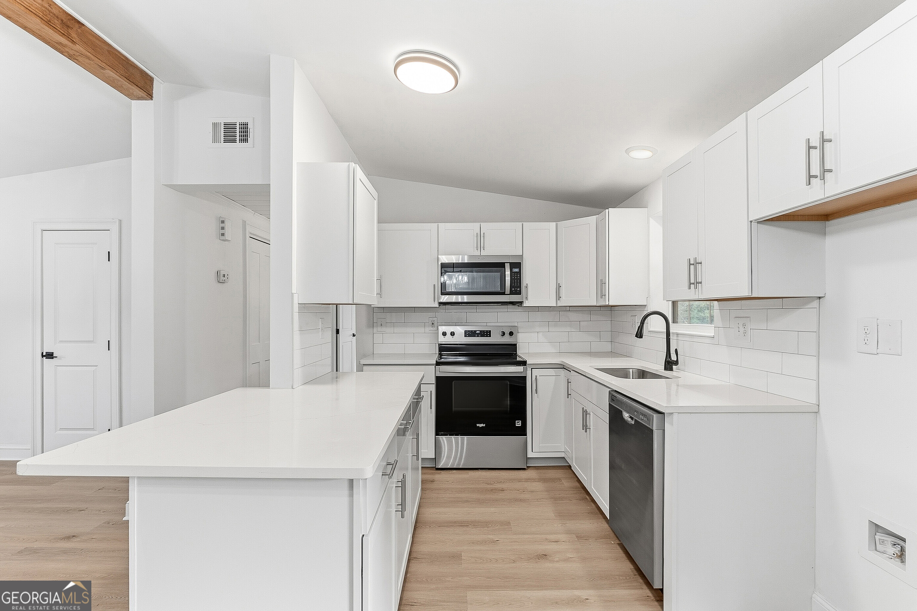 5393 Rogers Road Lizella, GA 31052 - Photo 11 of 52 a kitchen with stainless steel appliances granite countertop a stove top oven a sink and dishwasher with white cabinets