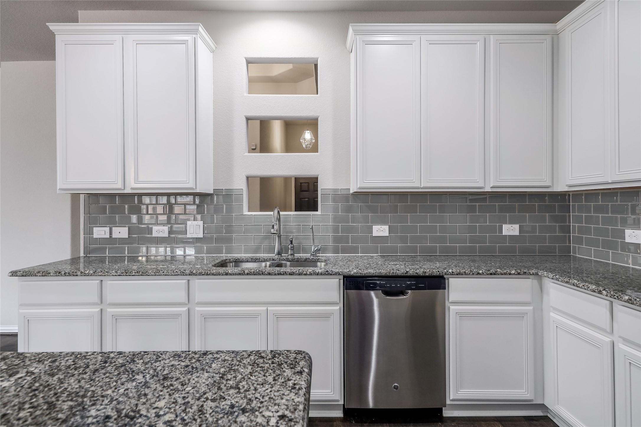 205 Penna Lane Georgetown, TX 78628 - Photo 10 of 32 White cabinetry, granite counters, and stainless steel appliances furnish this well-appointed kitchen.