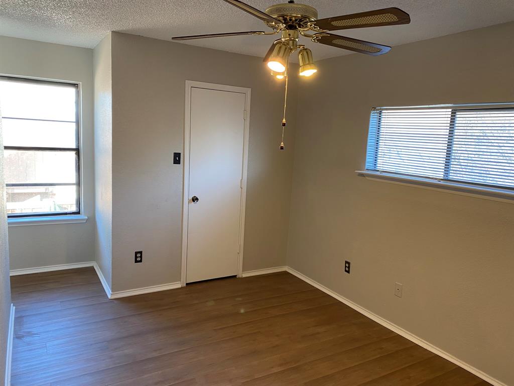 134 Main Place Euless, TX 76040 - Photo 16 of 25 an empty room with wooden floor fan and windows