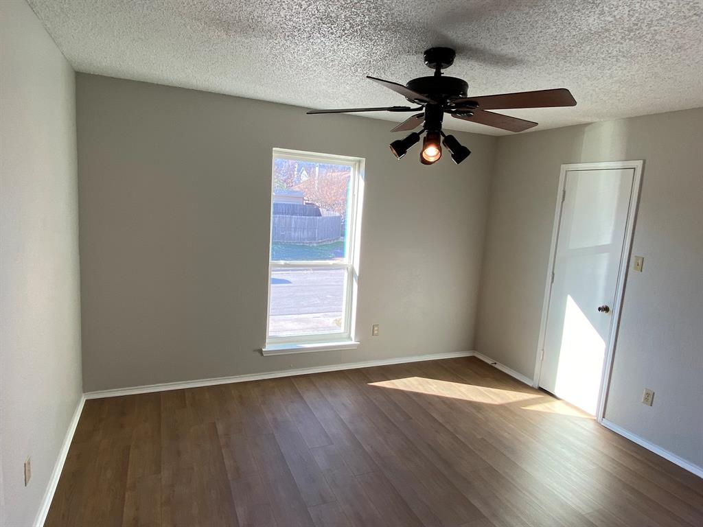 134 Main Place Euless, TX 76040 - Photo 9 of 25 wooden floor in an empty room with a window