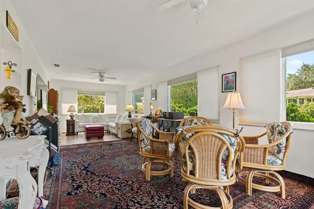 a living room with furniture a fireplace and large windows