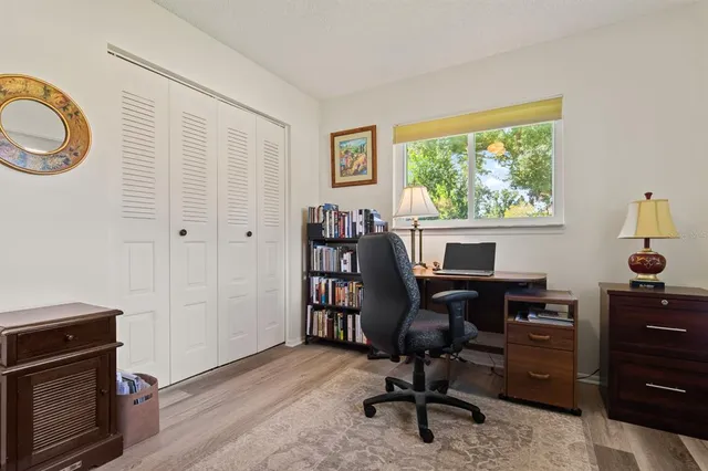 a view of a workspace with furniture and a window