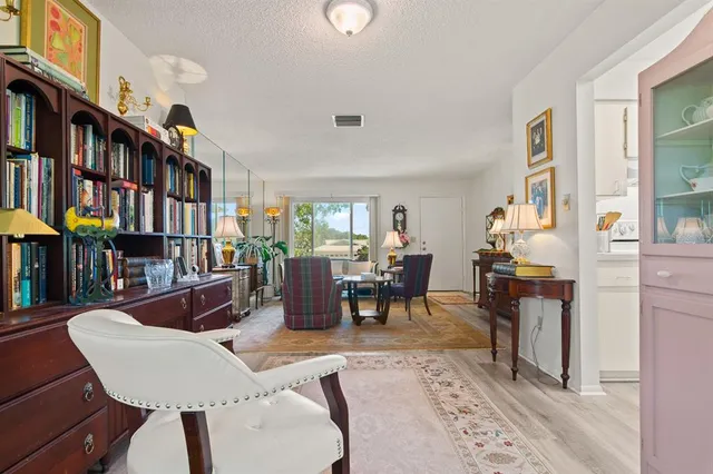 a living room with furniture a bookshelf and a window
