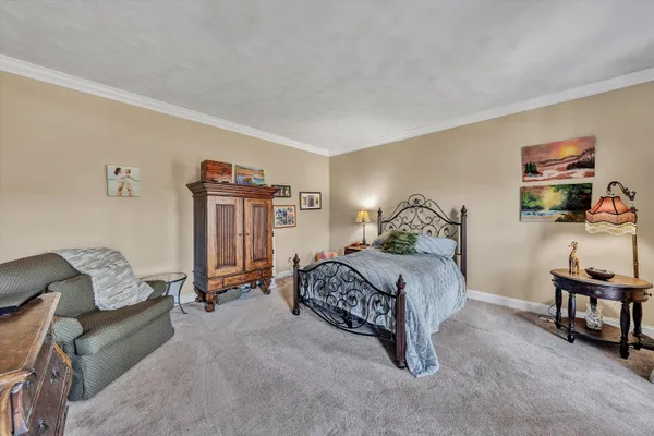 a large kitchen with kitchen island granite countertop lots of white cabinets appliances and a dining table