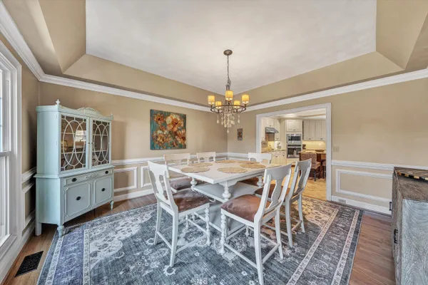 a kitchen with granite countertop a sink stainless steel appliances white cabinets and a window