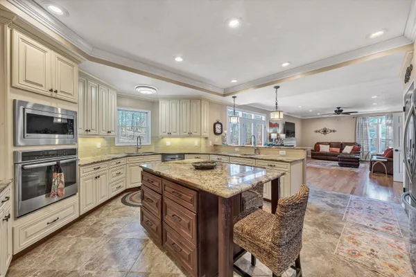 a view of kitchen with kitchen island stainless steel appliances refrigerator stove microwave and cabinets