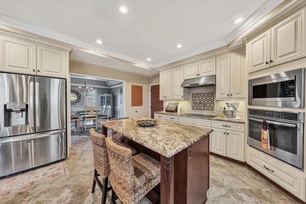 a spacious bedroom with a bed a chandelier and a large window
