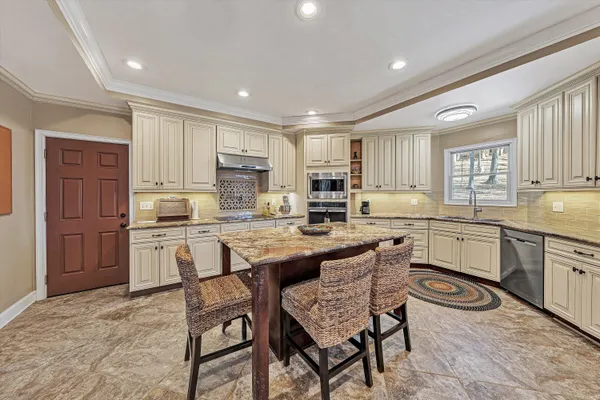 a bedroom with a bed a couch and a chandelier