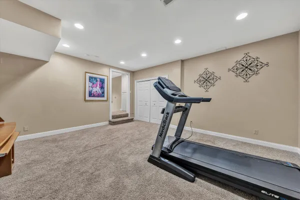 a front view of a house with a yard covered with snow in the background