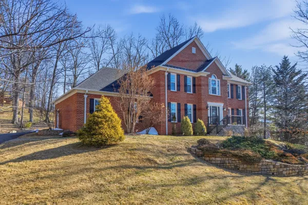 a view of a brick house with many windows and a tree