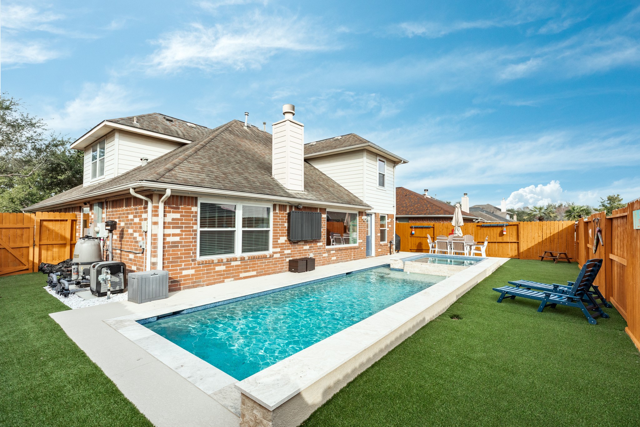 4113 Merlet Drive Pearland, TX 77584 - Photo 2 of 36 Backyard oasis featuring a 5-foot deep pool, a hot tub accommodating eight people, artificial turf surrounding the pool, and a new fence. Ideal for entertaining and family gatherings.