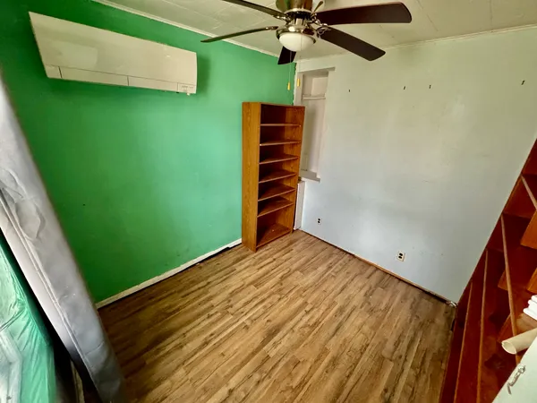 a view of empty room with a window and a ceiling fan
