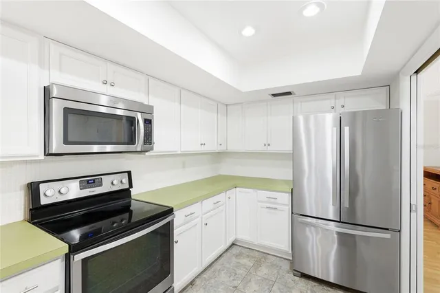 an empty room with wooden floor closet and fan
