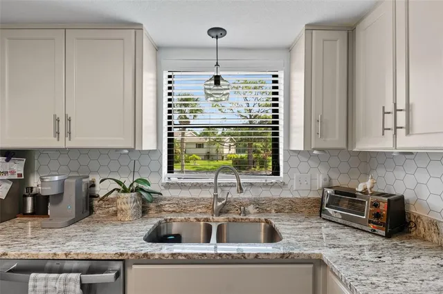a kitchen with granite countertop a sink and a stove
