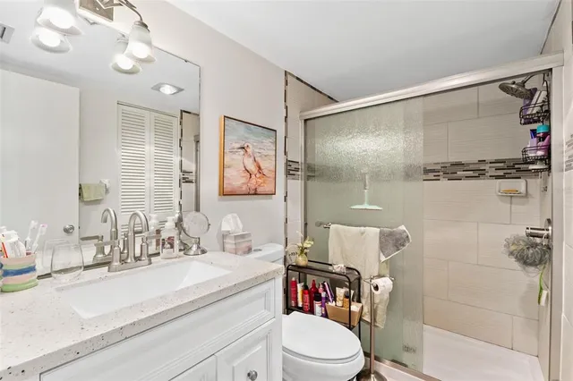 a bathroom with a sink vanity granite and toilet