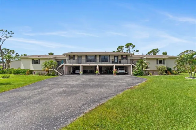 a view of a house with a yard and potted plants