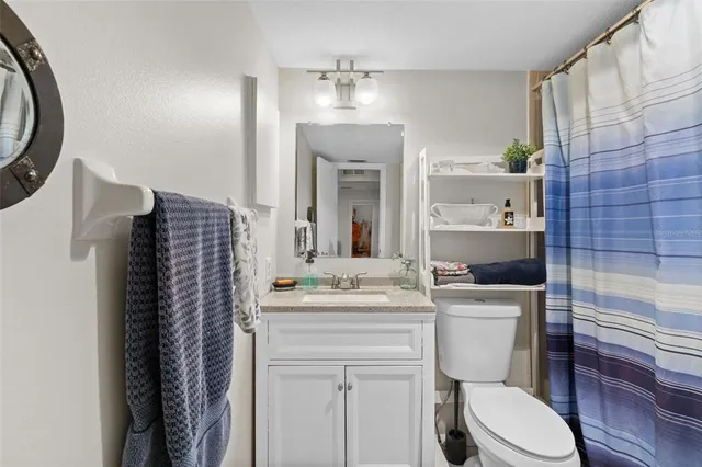 a bathroom with a sink toilet vanity and tub