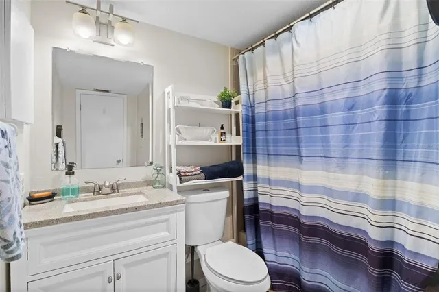 a bathroom with a sink a toilet and shower curtain