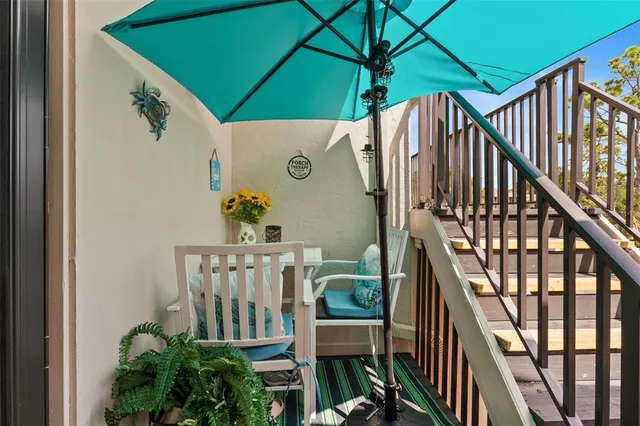 a view of balcony with furniture and umbrella