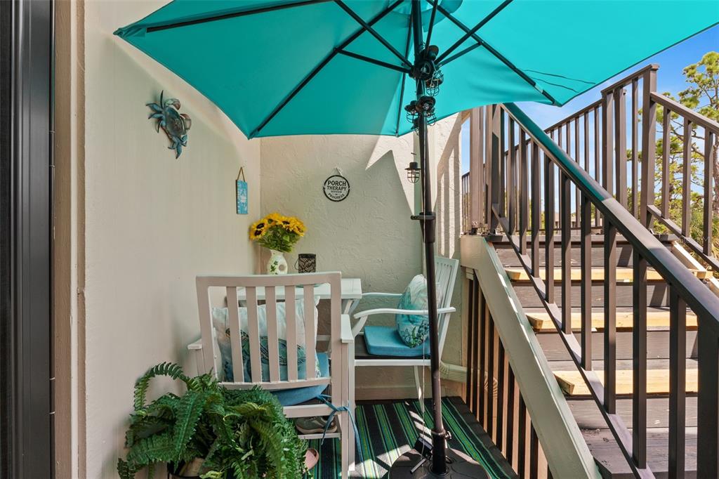 4260 Placida Road, Unit 17A Englewood, FL 34224 - Photo 33 of 34 a view of balcony with furniture and umbrella