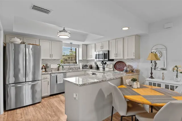 a kitchen with granite countertop a sink stainless steel appliances and cabinets