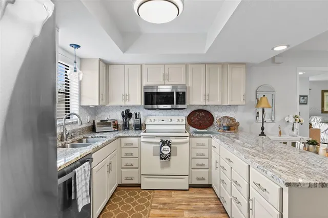 a kitchen with stainless steel appliances granite countertop a sink and a stove