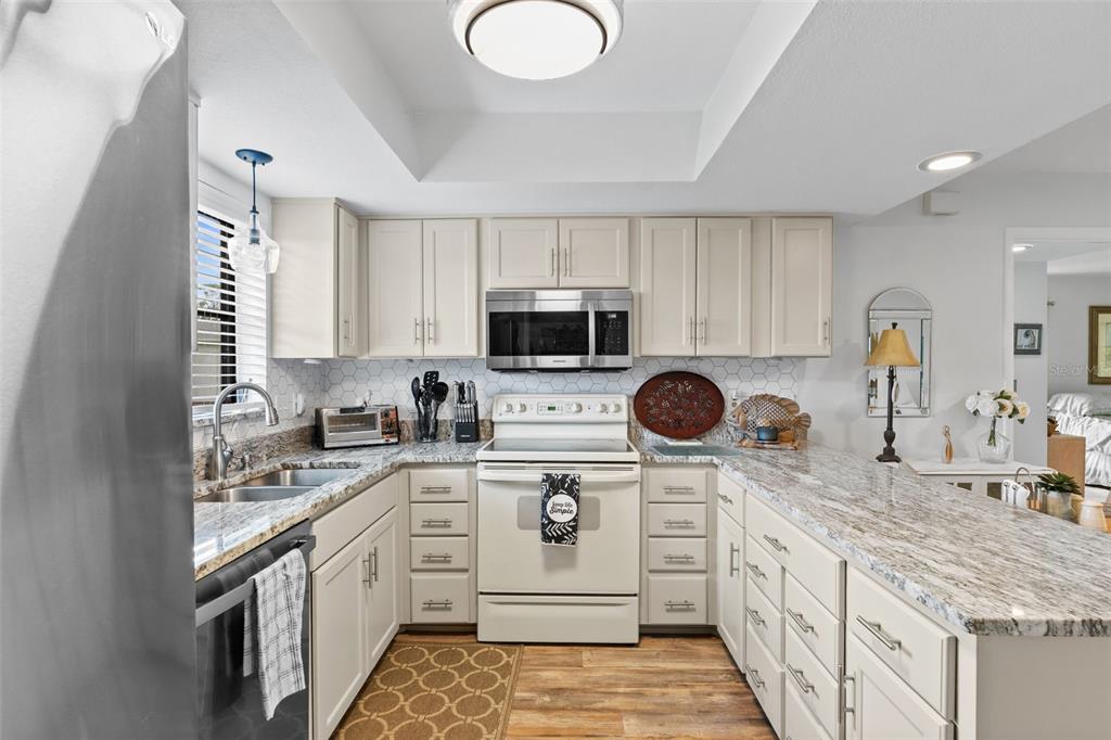 4260 Placida Road, Unit 17A Englewood, FL 34224 - Photo 10 of 34 a kitchen with stainless steel appliances granite countertop a sink and a stove