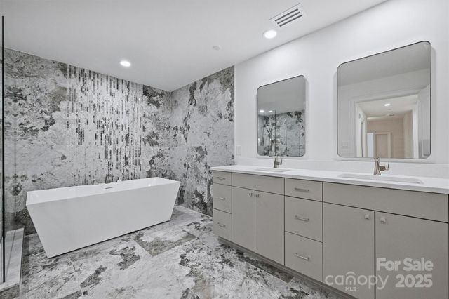a bathroom with a bathtub sink and mirror