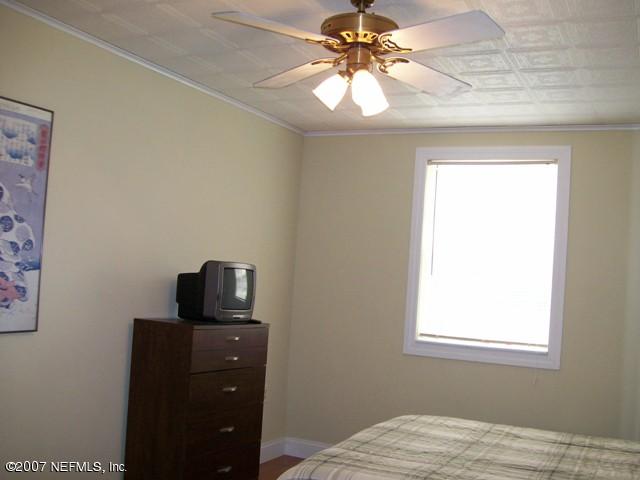 4012 Dover Road Jacksonville, FL 32207 - Photo 12 of 20 a bedroom with a bed and a flat tv screen on a dresser